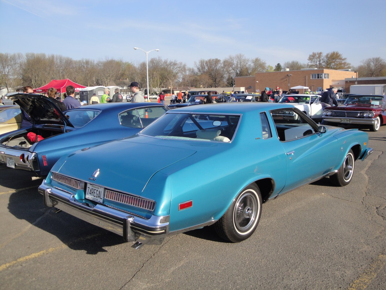 Rear and side view of a classic mid-70s coupe in blue at a car event