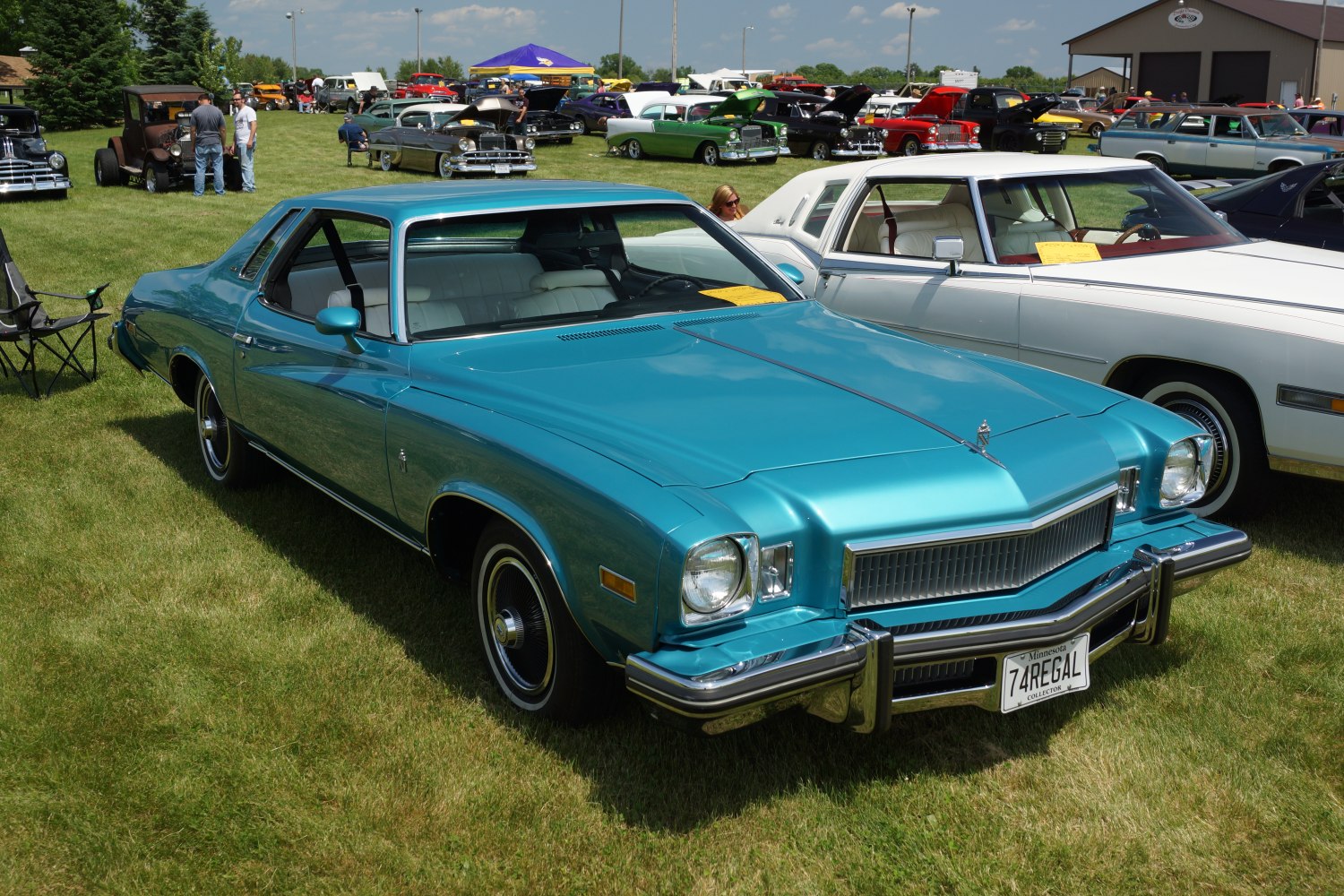 Vintage blue coupe with prominent front grille and chrome bumper