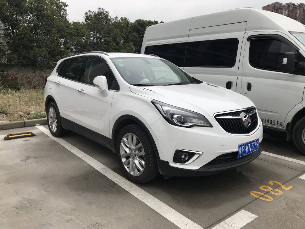 Front-side view of a white SUV with distinctive headlights and grille.