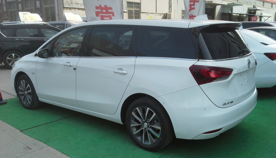 White minivan rear side with tinted windows and alloy wheels