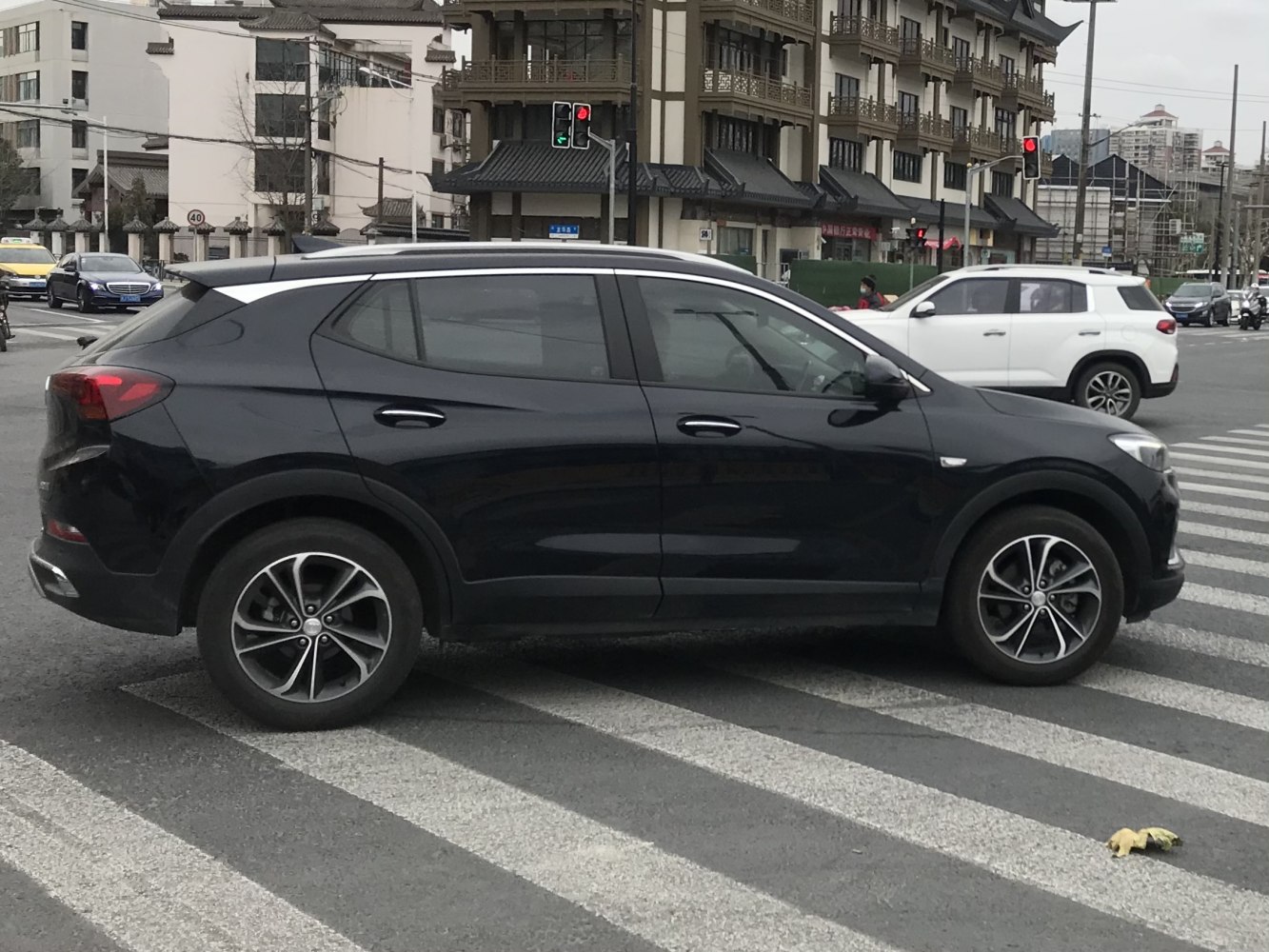 Modern black SUV with alloy wheels at a city intersection