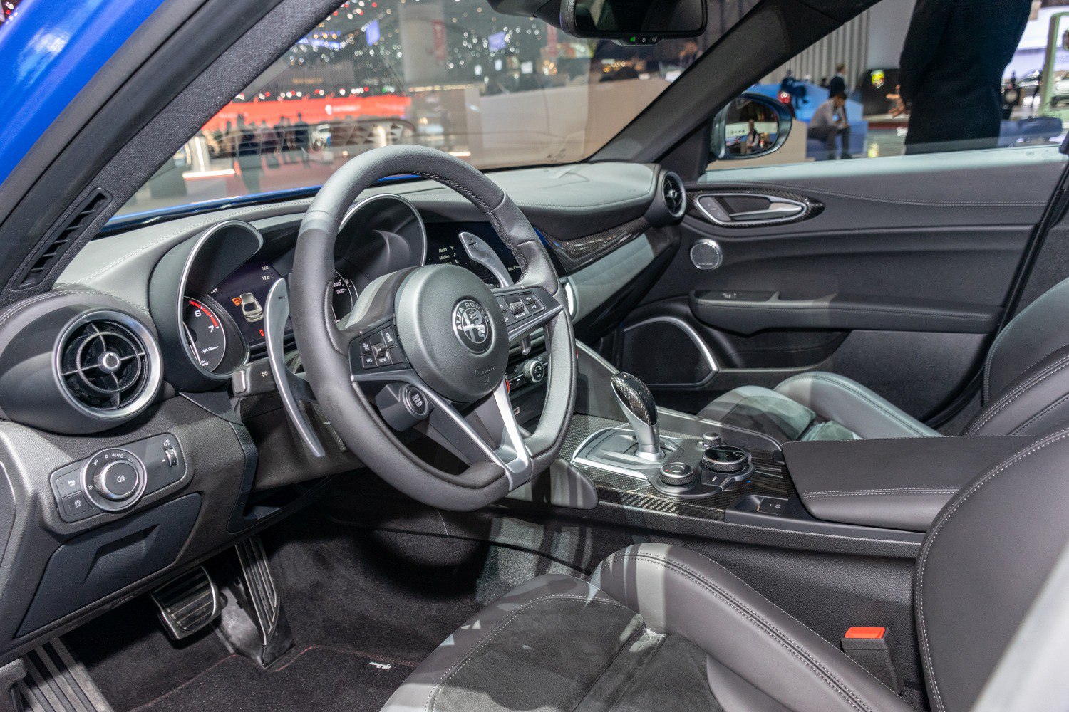 Sporty steering wheel and sleek gear shifter inside a premium car interior