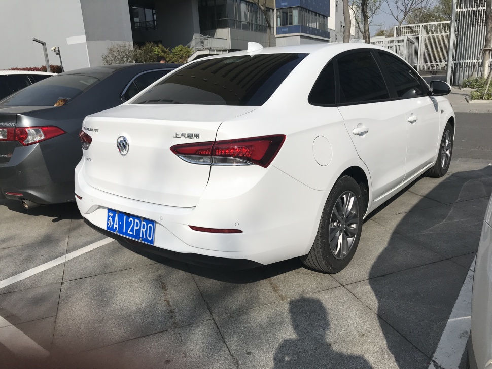 Rear and side view of white sedan with sharp tail lights