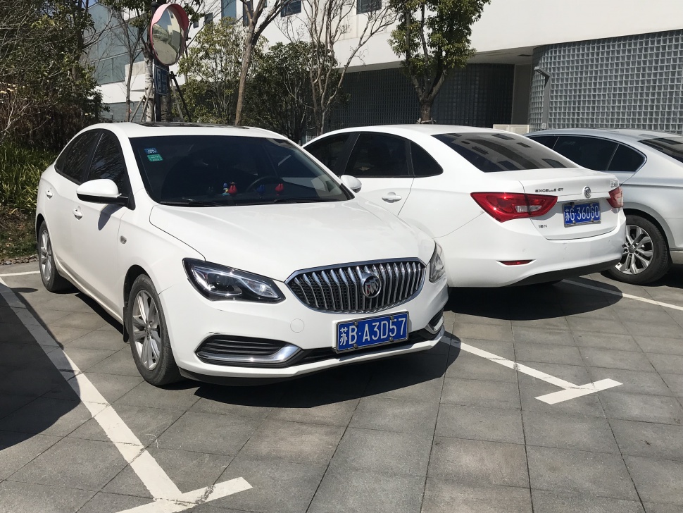 White sedan with front grille and rear tail light views