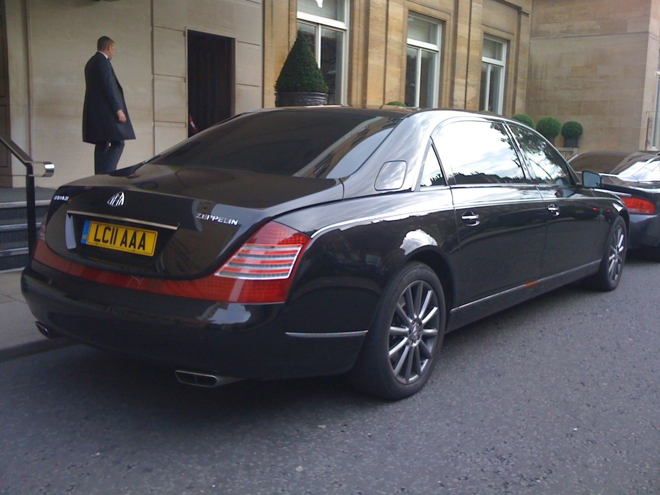 Rear view of luxury black sedan with distinctive taillights and chrome accents.