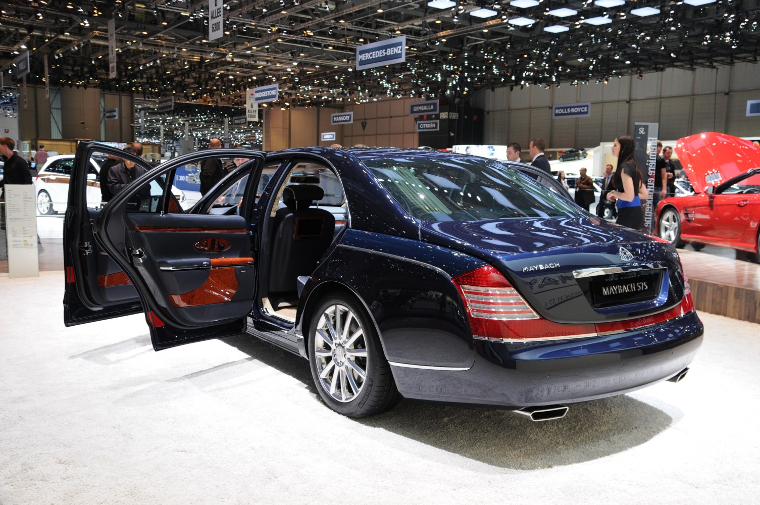 Luxury sedan rear view with open rear door and wood-trimmed interior