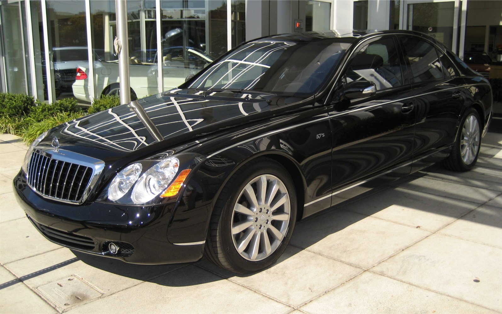 Black luxury sedan with chrome grille and large alloy wheels