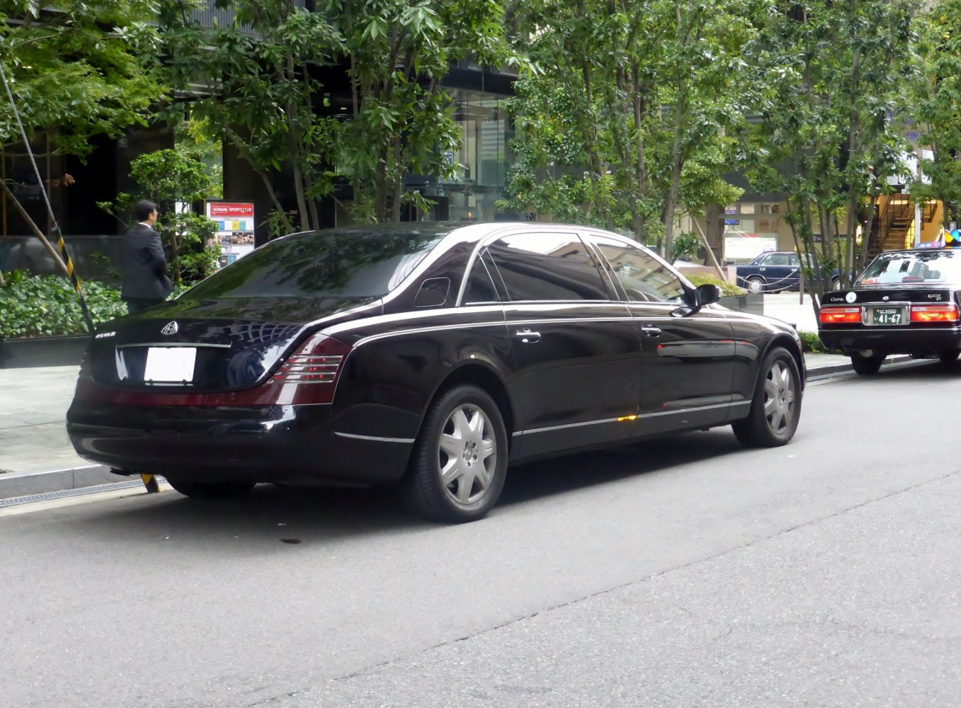 Luxury black sedan rear side with distinctive tail lights and long wheelbase.