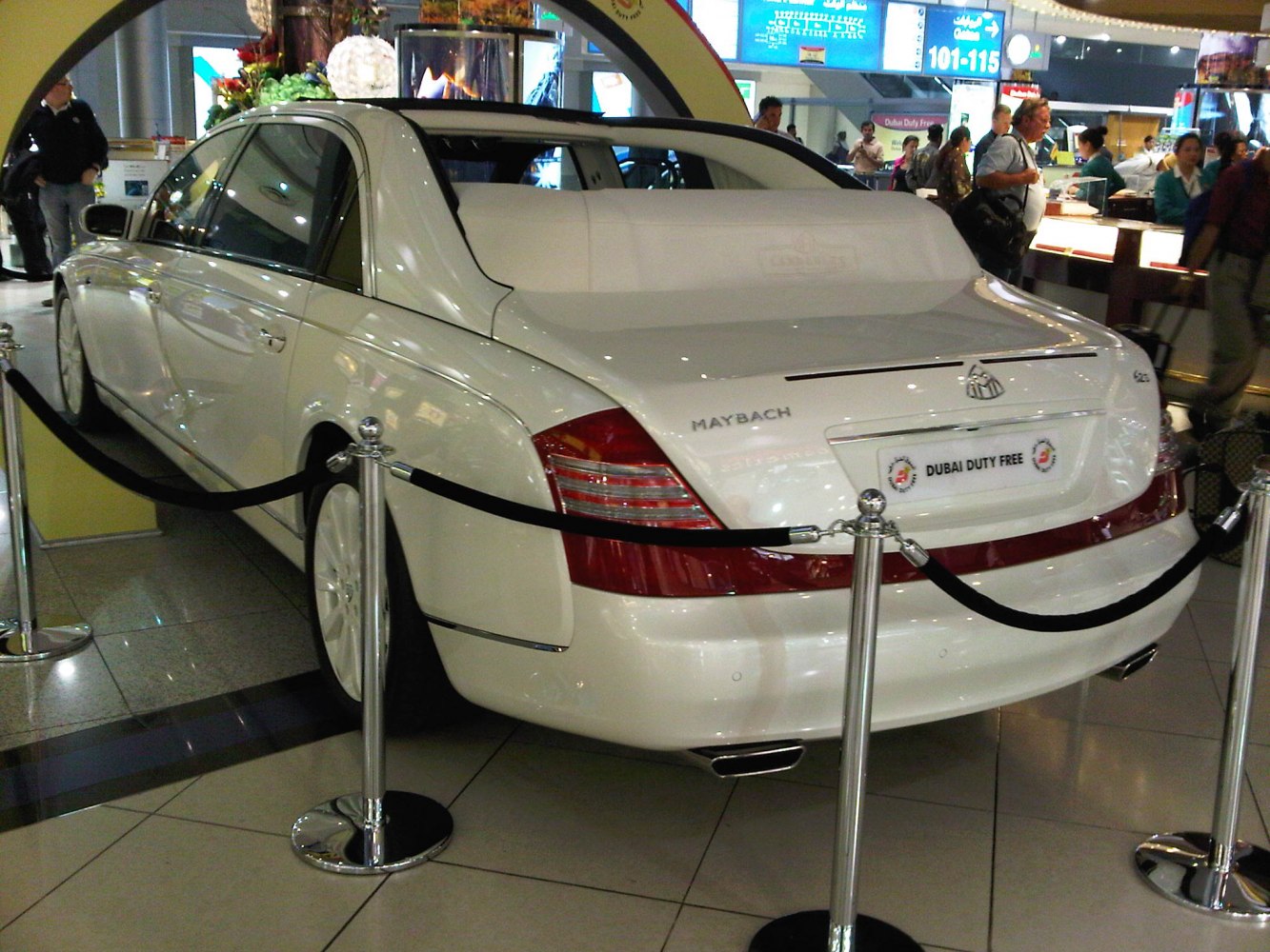 Luxury sedan rear with chauffeur partition under showroom lighting