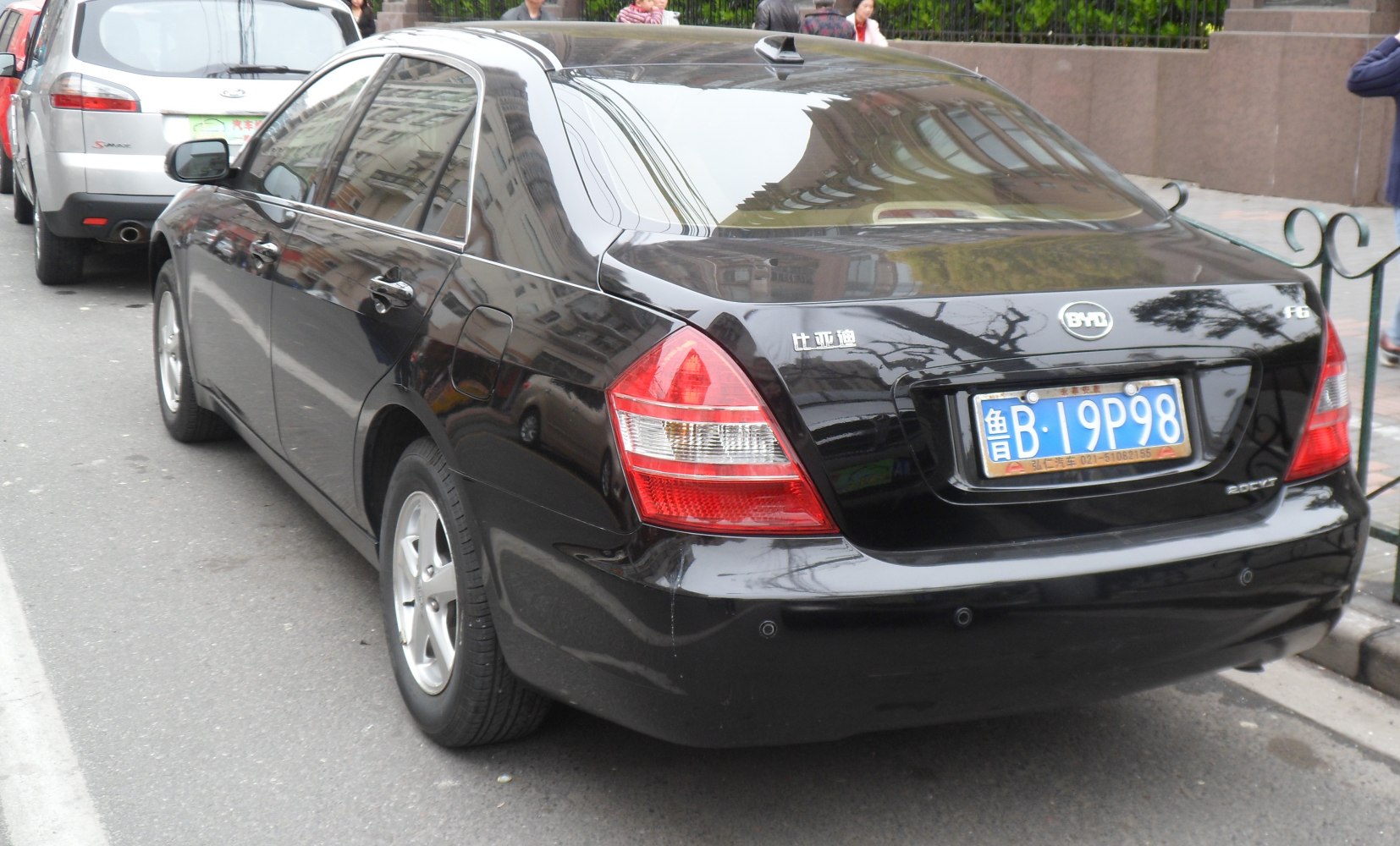 Black sedan rear view with distinct taillights and a rear bumper