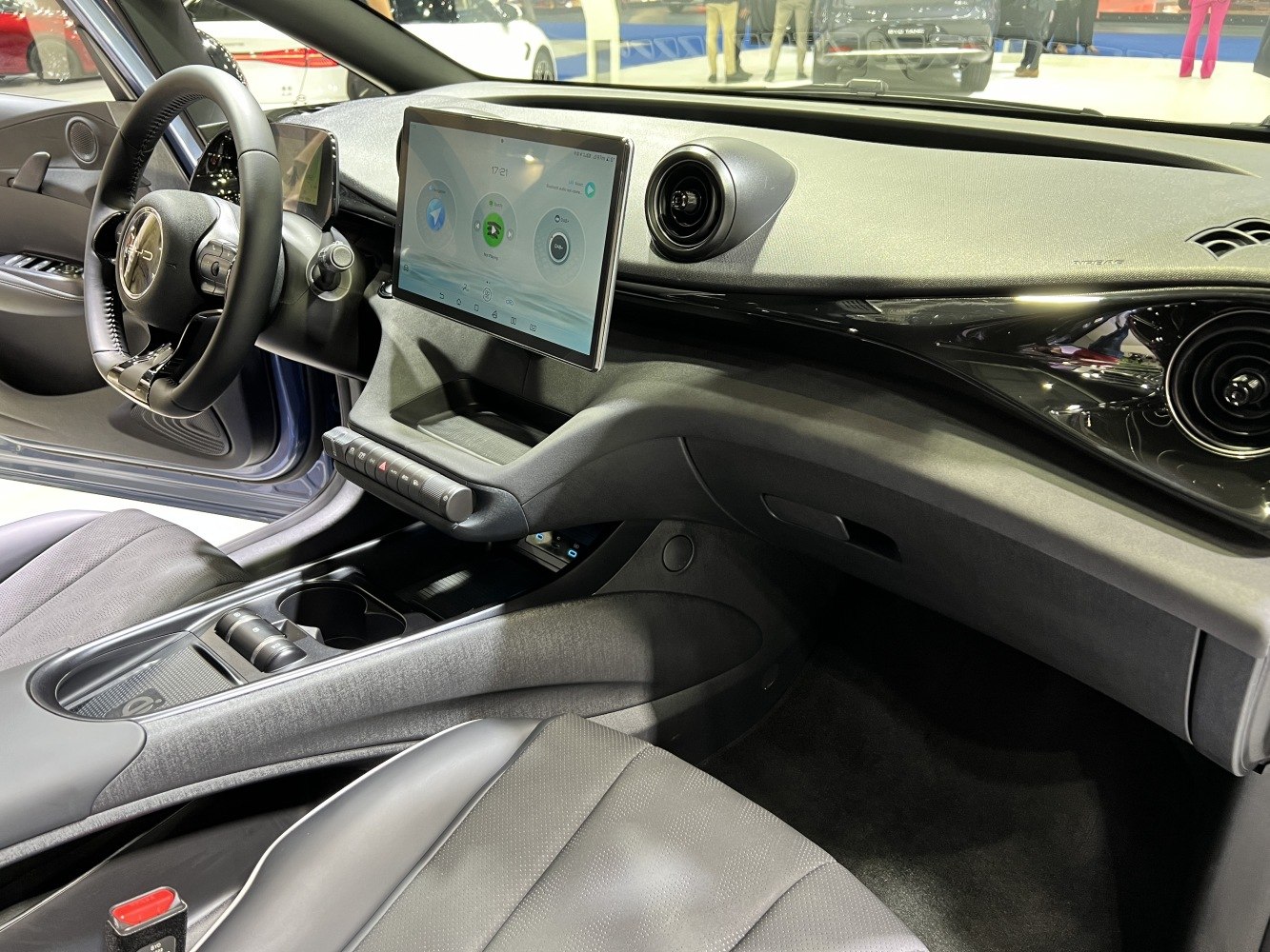 Dashboard with touchscreen, circular air vents, modern steering wheel, center console storage
