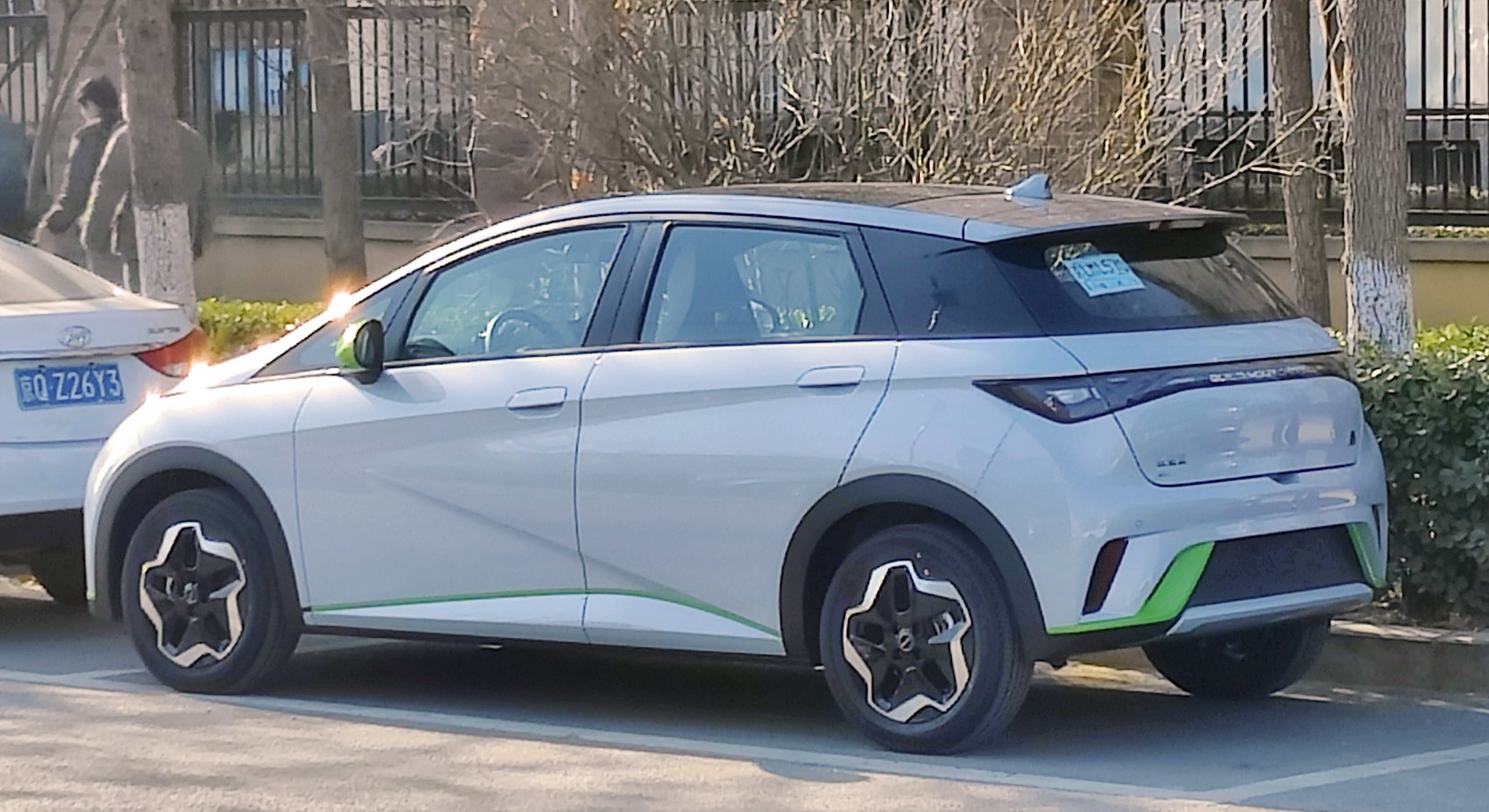 Side and rear profile with star-design wheels and green accent lines