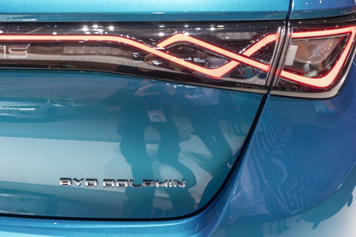 Close-up of rear tail light and BYD Dolphin badge on blue car