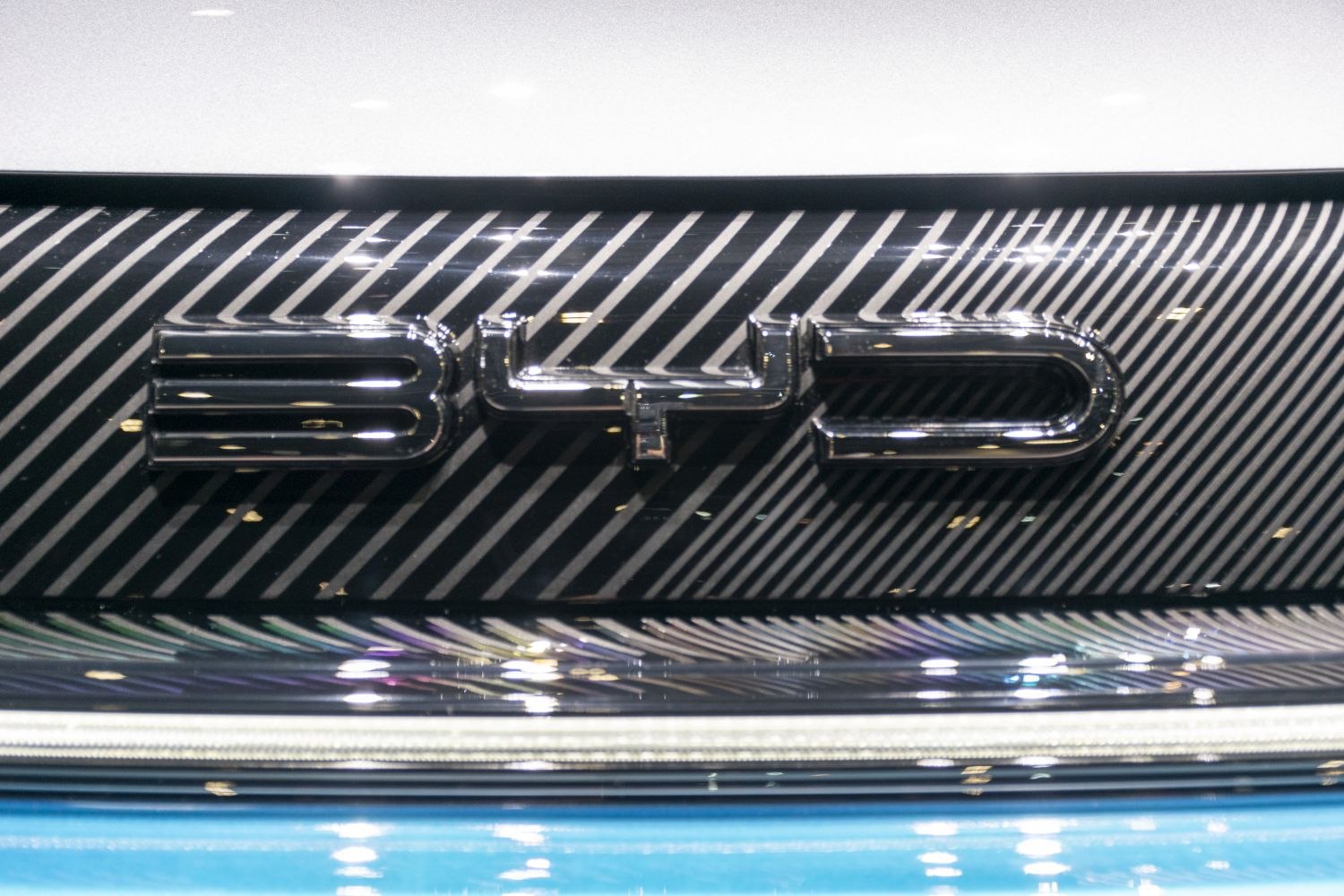 Close-up of front badge with carbon fiber pattern and chrome emblem