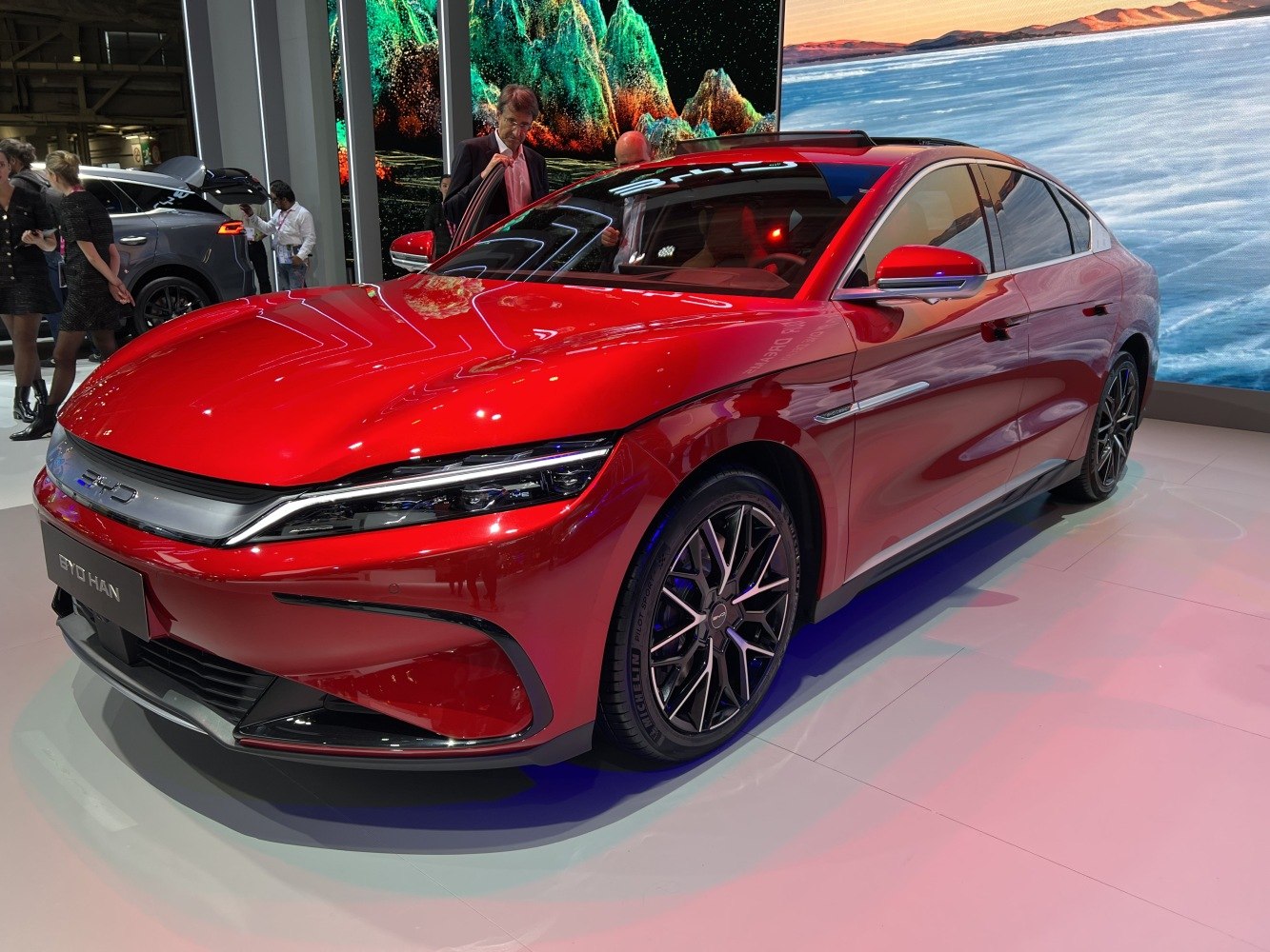 Red electric sedan with sharp LED headlights and stylish alloy wheels