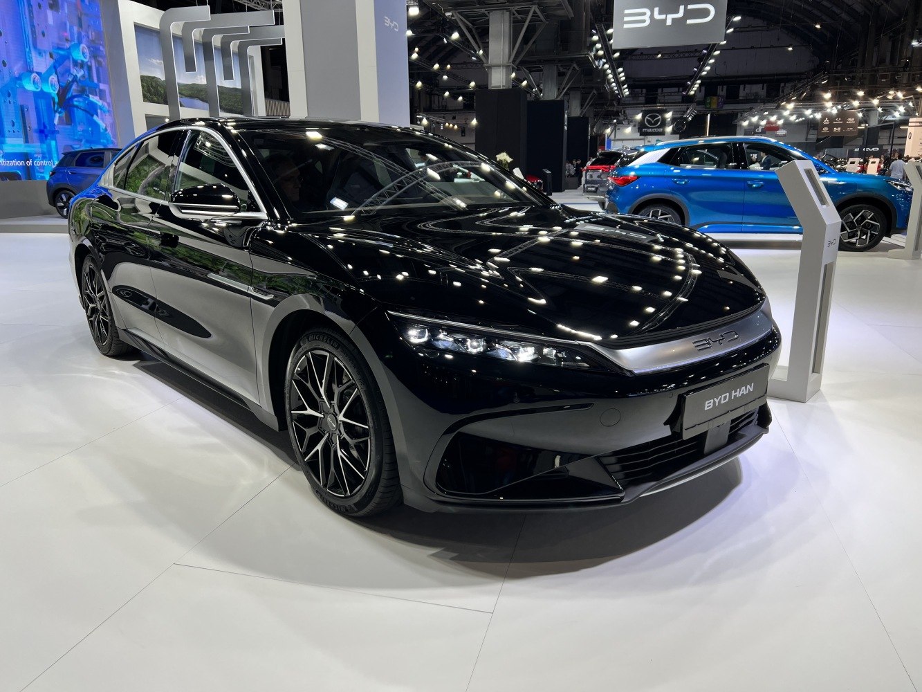 Black electric sedan with LED headlights and alloy wheels.