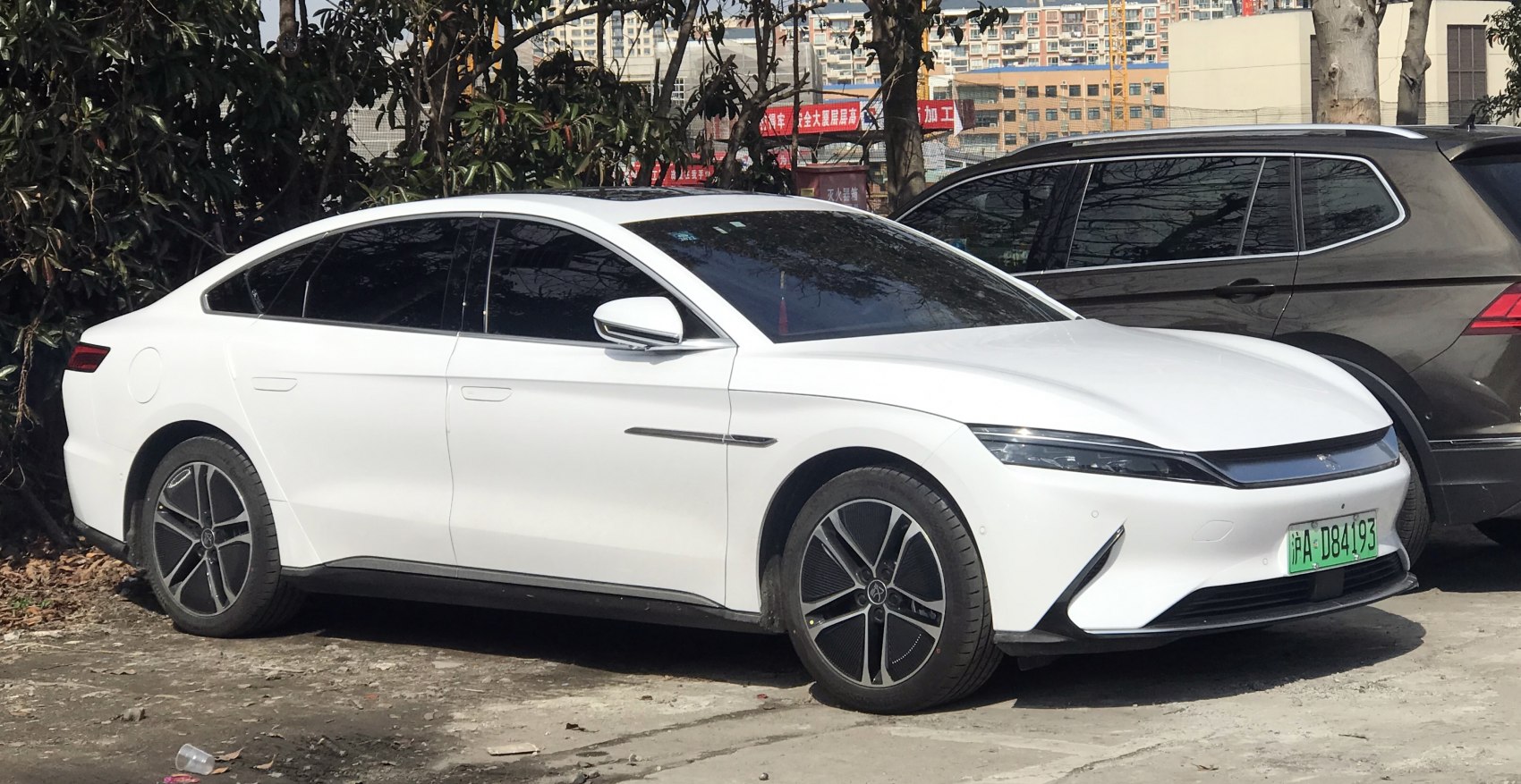 White electric sedan with narrow LED headlights and distinctive alloy wheels