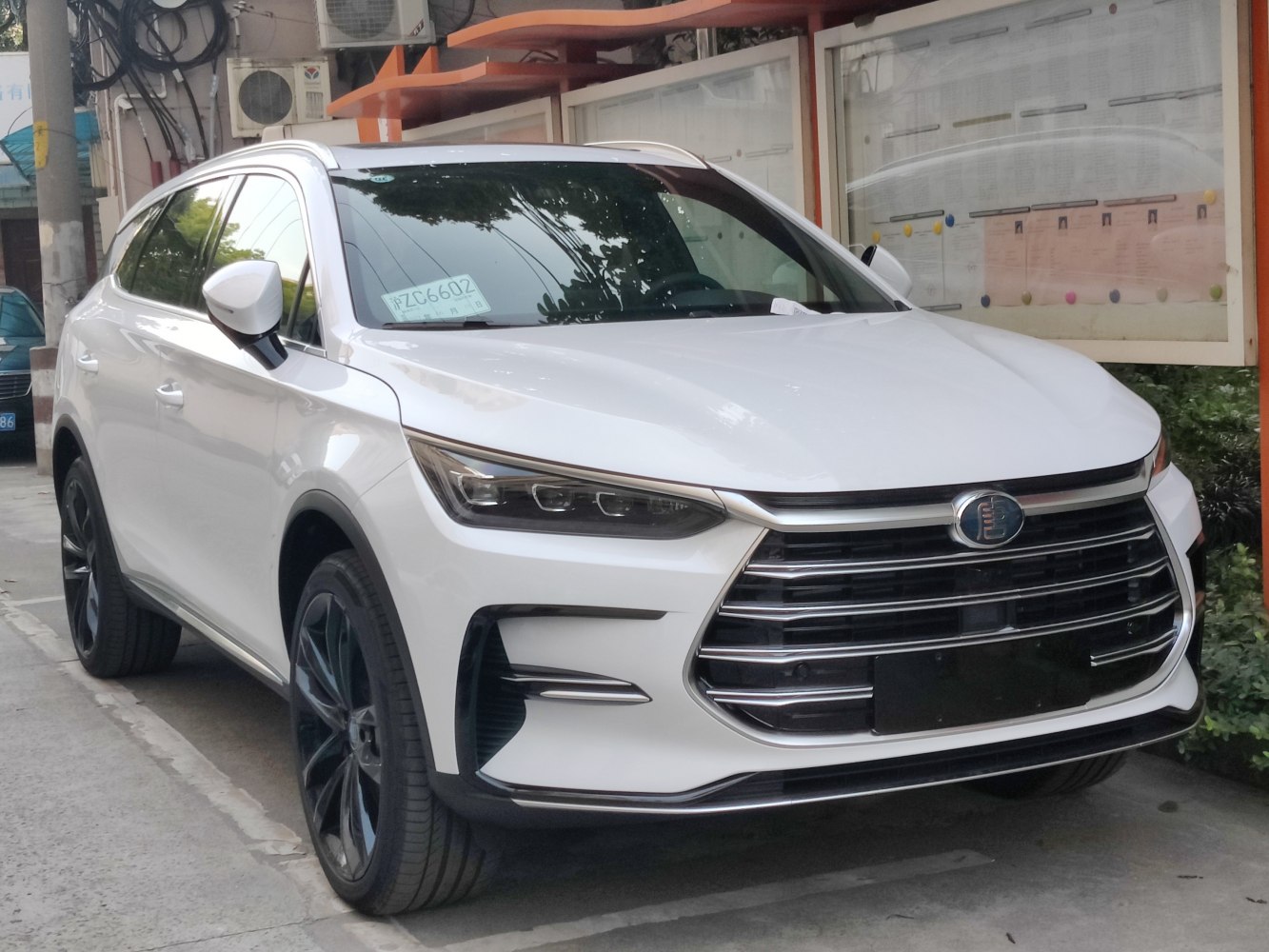 Prominent large front grille and sleek LED headlights on white SUV