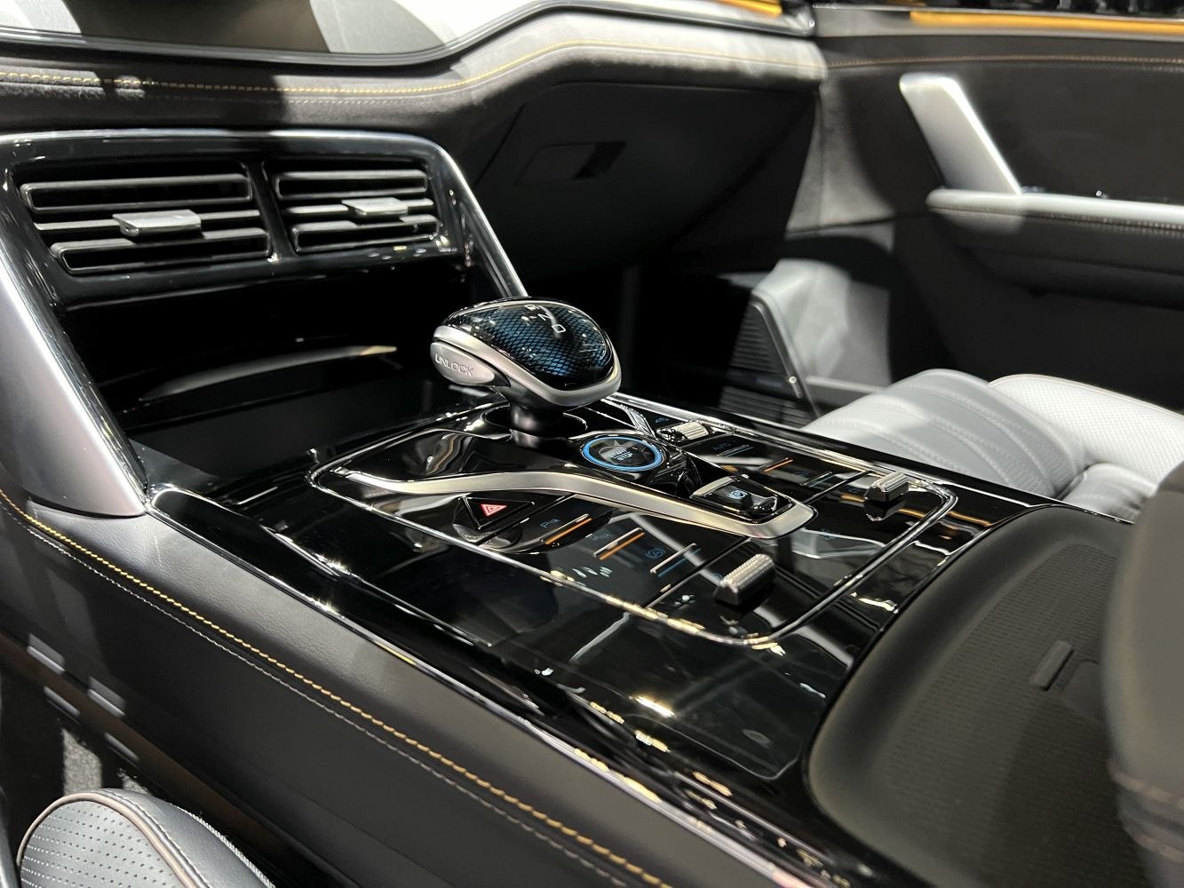 Close-up of sleek gear shift and black glossy center console