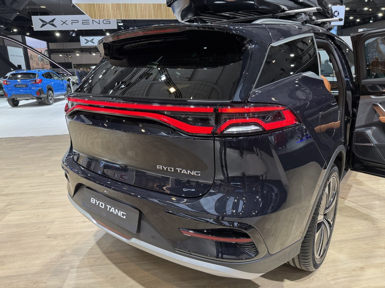 Rear view with distinctive red LED tail light strip and black SUV body.