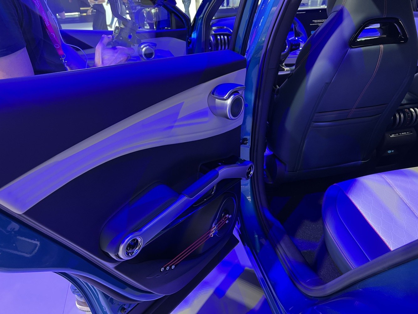 Rear door panel with unique speaker design, rear passenger seat in modern interior