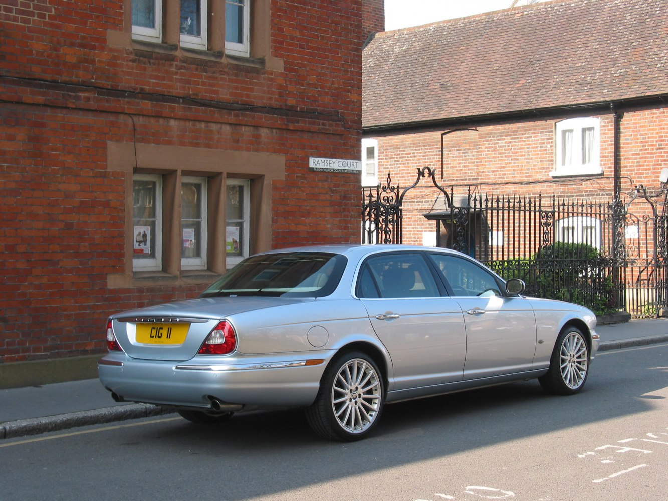 Rear side view of silver luxury sedan with multi-spoke alloy wheels