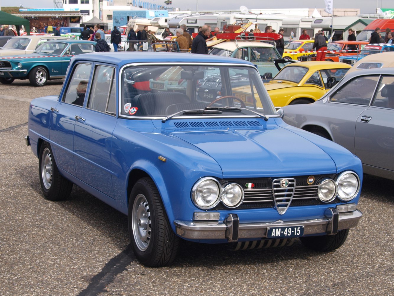 Classic vintage blue sedan front with round headlights and chrome bumper.