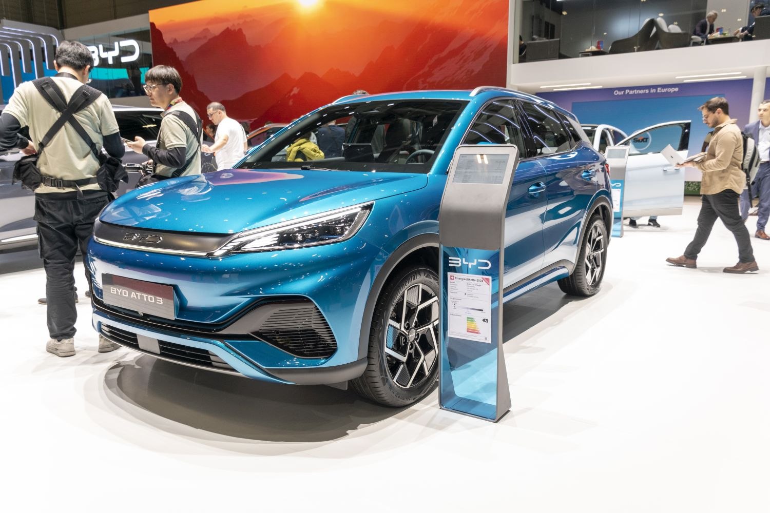Front view of modern electric SUV with sleek LED headlamps and geometric wheel design.