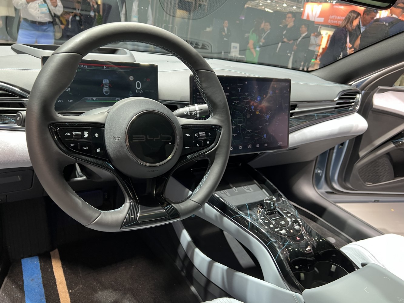 Electric car interior with digital screens and multifunction steering wheel.