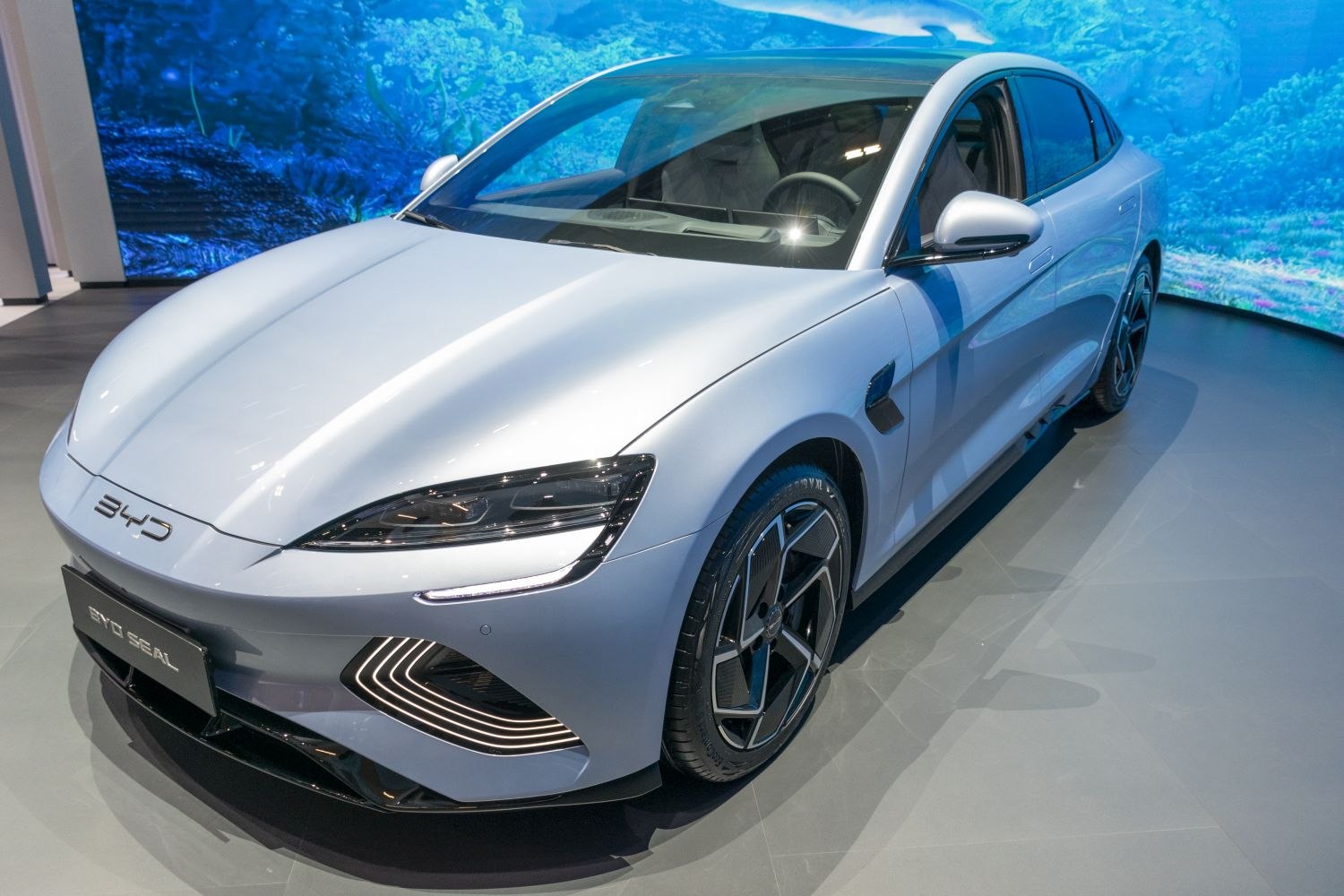 Futuristic LED headlights and aerodynamic multi-spoke wheels on a sleek electric sedan