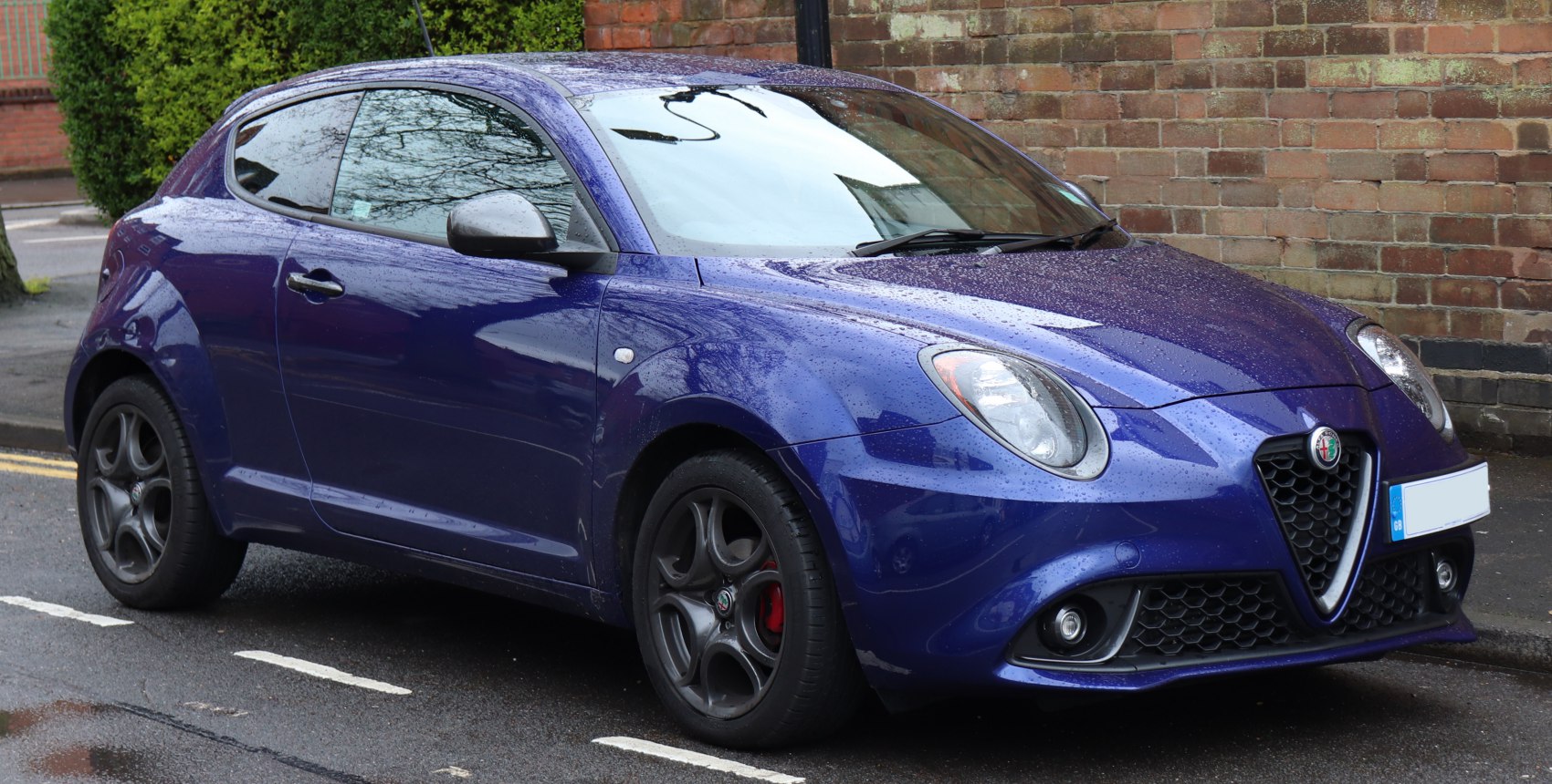 Blue hatchback with distinctive round headlights and sporty alloy wheels