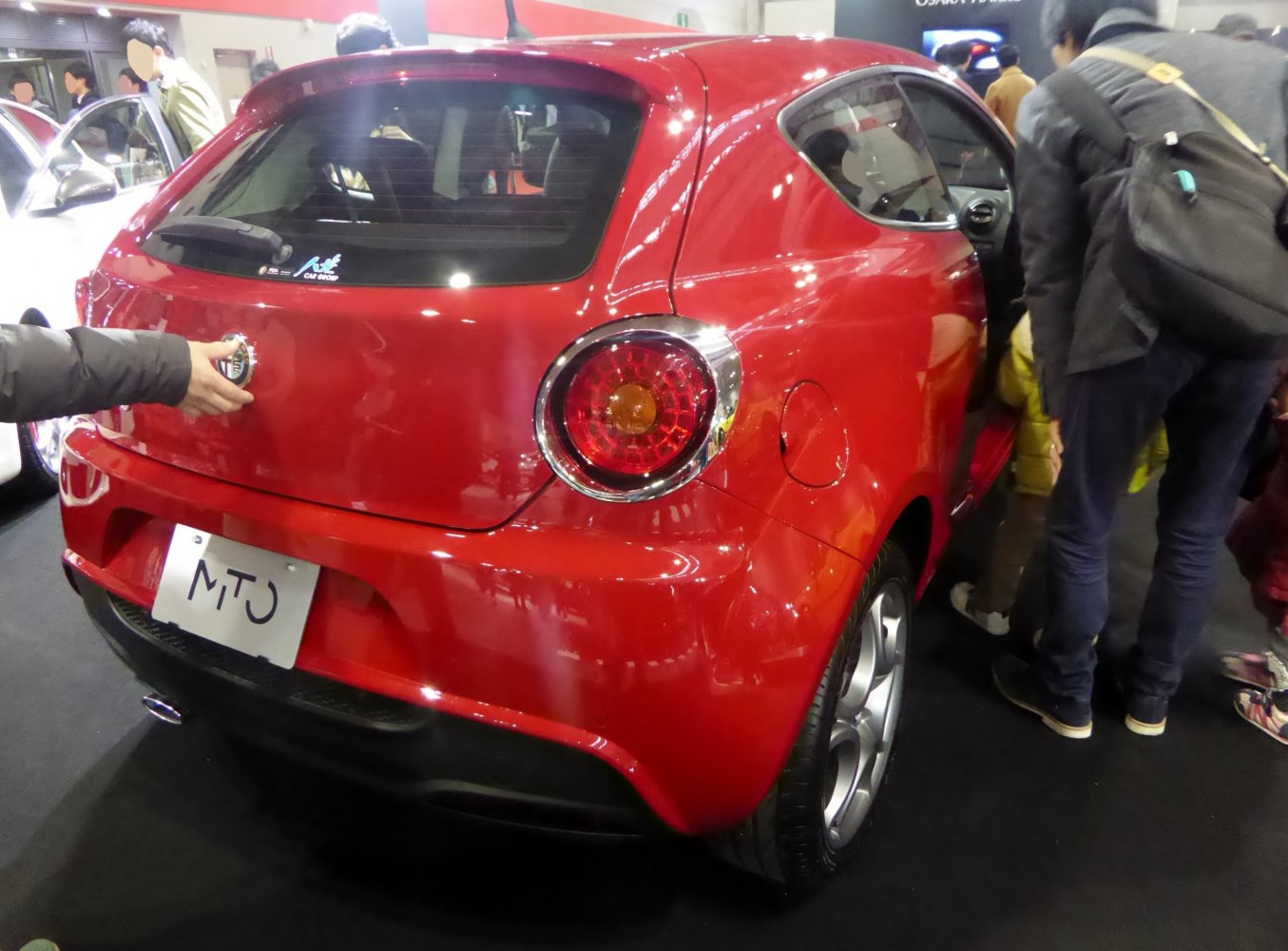Rear of red compact hatchback with round tail lights and sporty design