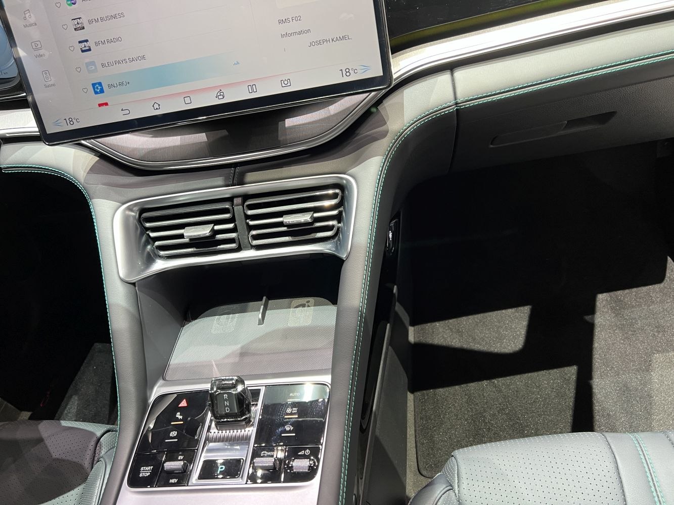 Modern electric vehicle center console with large touchscreen and innovative shift lever