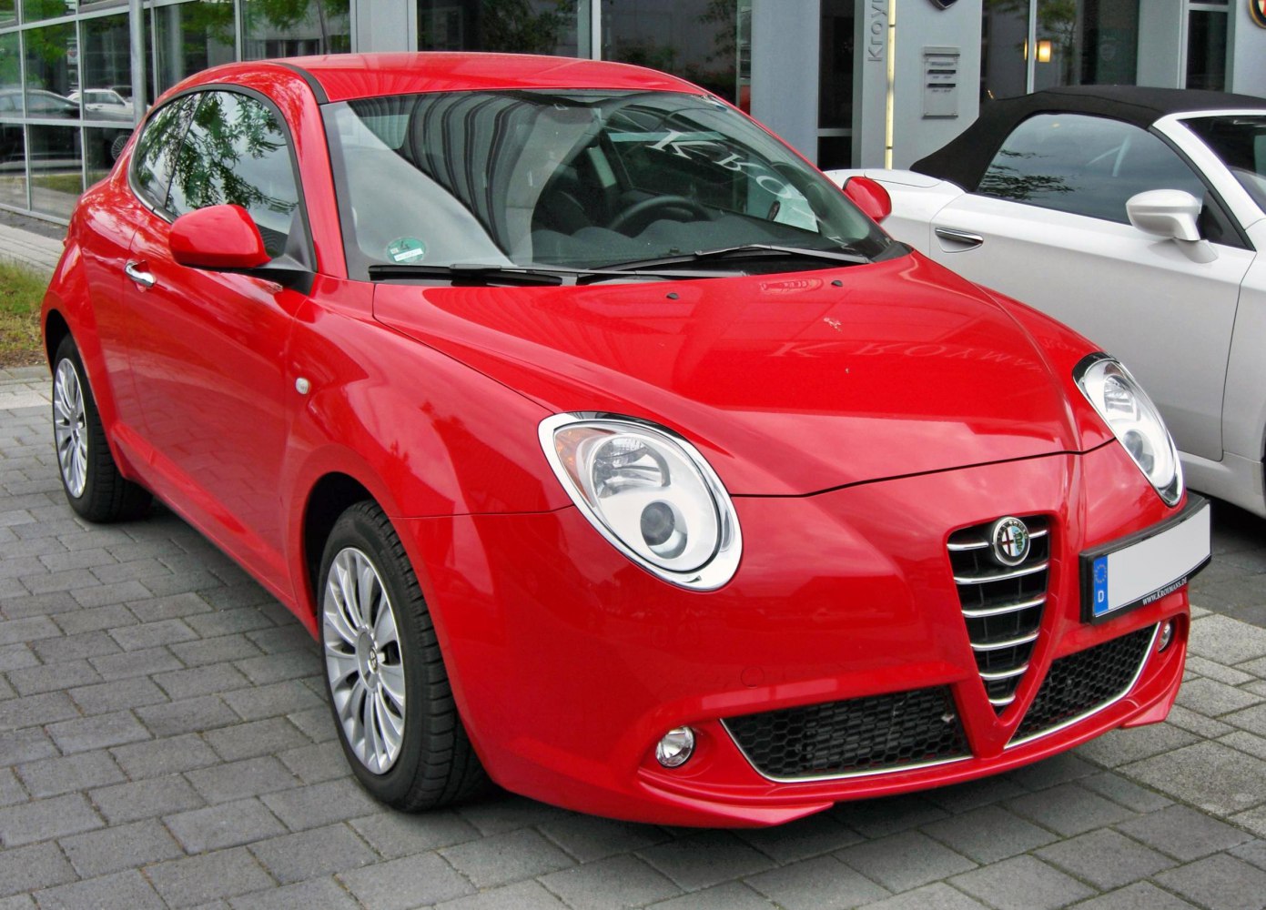Red hatchback with rounded headlights and distinctive front grille