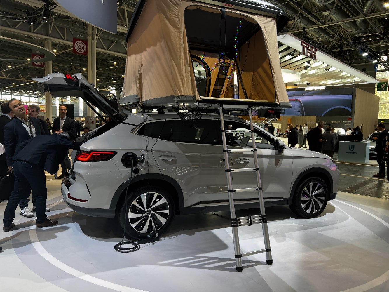Electric SUV with rooftop tent and charging cable setup