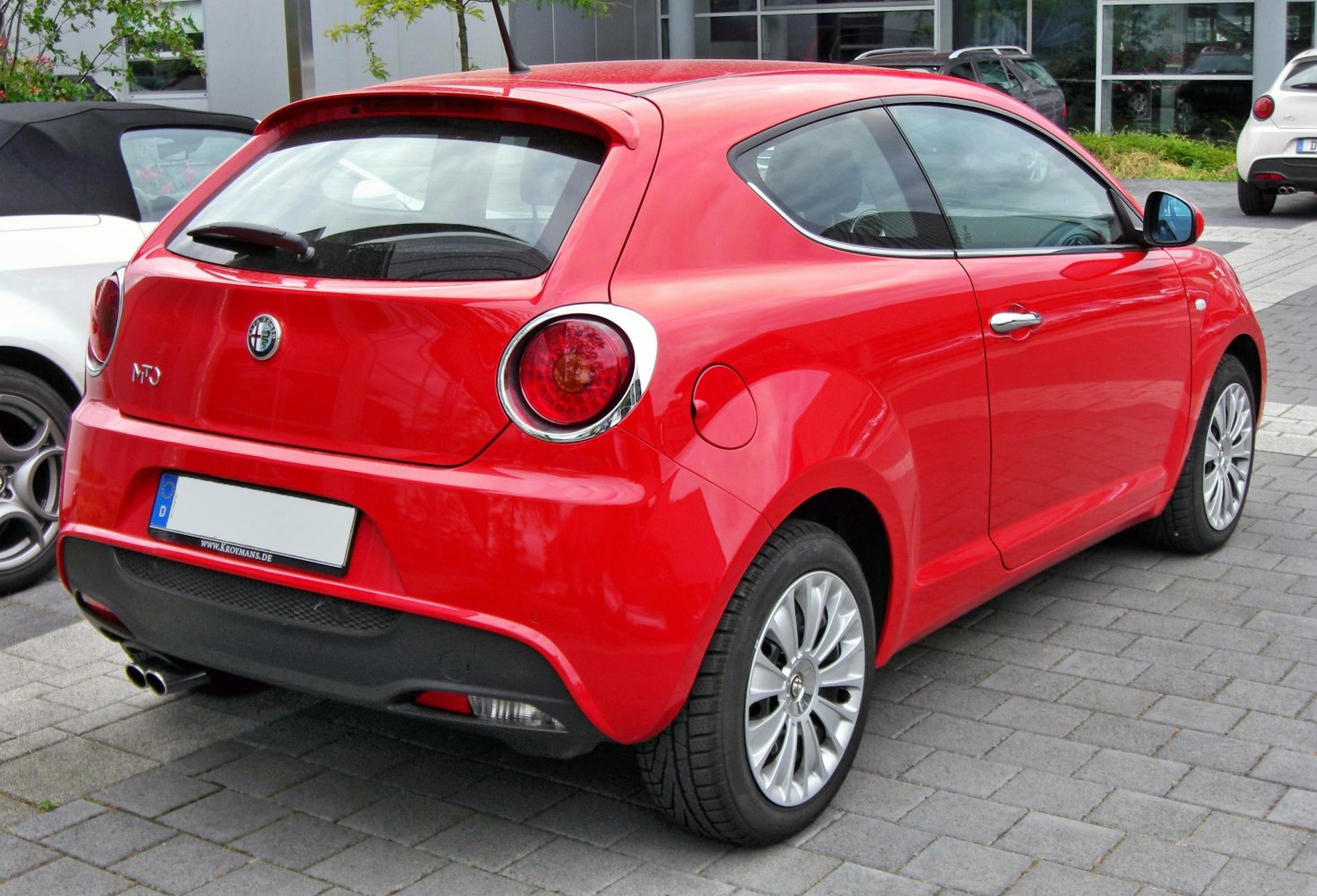 Rear view of compact hatchback with circular tail lights and twin exhaust pipes