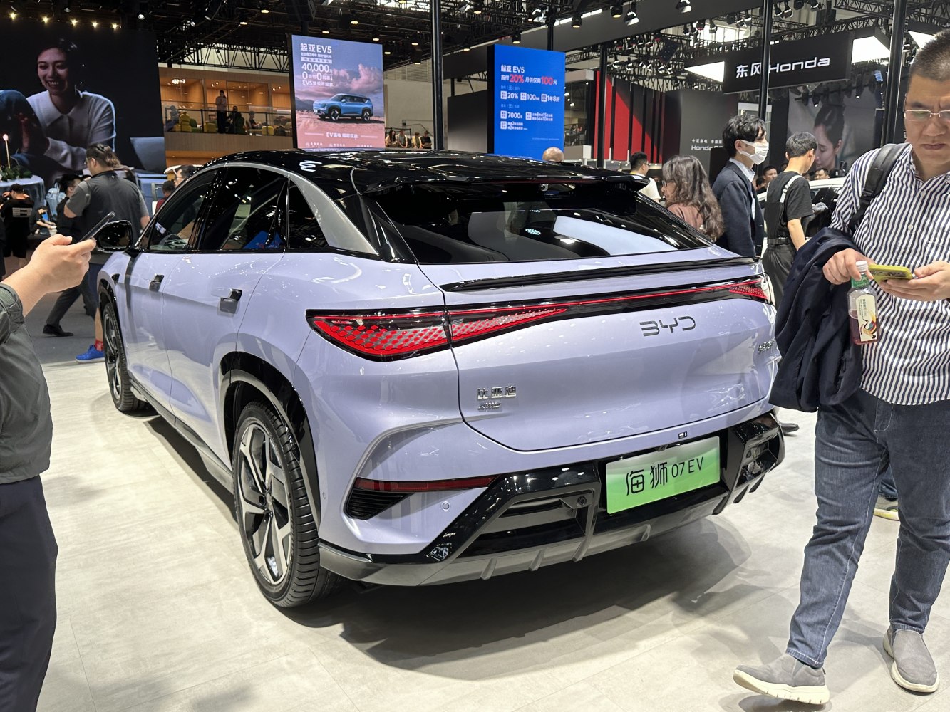 Rear view of an electric SUV with sleek taillights and black roof design