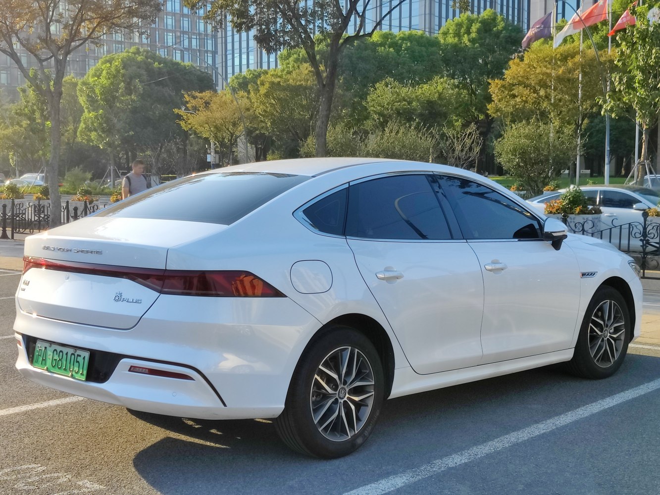 White sedan with rear and side visible in daylight urban setting.