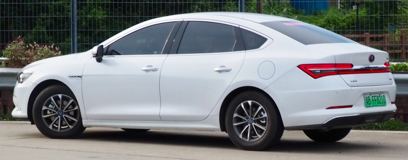 Side profile and rear view of a modern four-door sedan with distinct taillights.