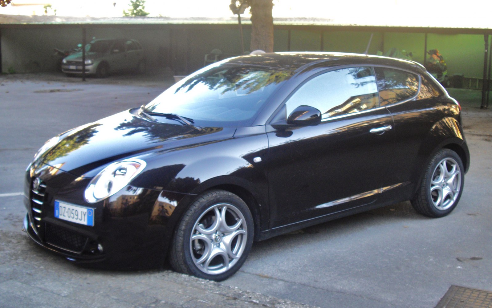 Compact black hatchback with round headlights and alloy wheels