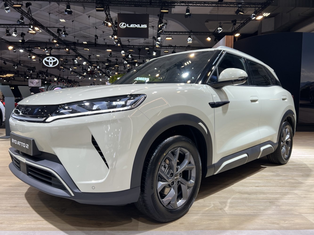 Front side view of white electric SUV with sleek headlights and alloy wheels.