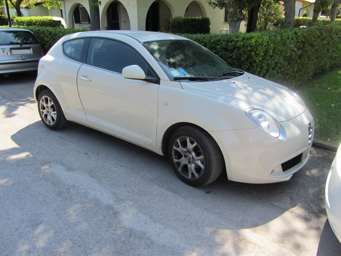 White compact hatchback with rounded headlights and alloy wheels