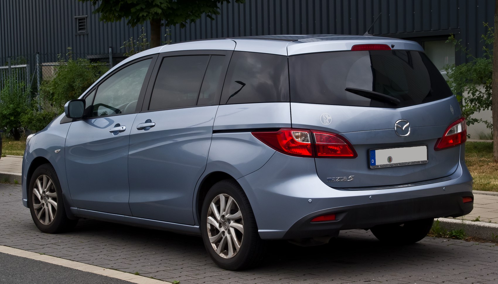 Rear-side view of compact multi-door vehicle with tinted windows and alloy wheels