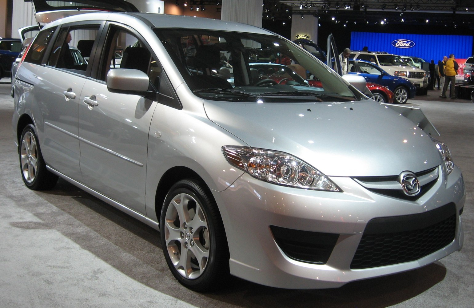 Silver multi-purpose vehicle with sleek headlights and sporty alloy wheels
