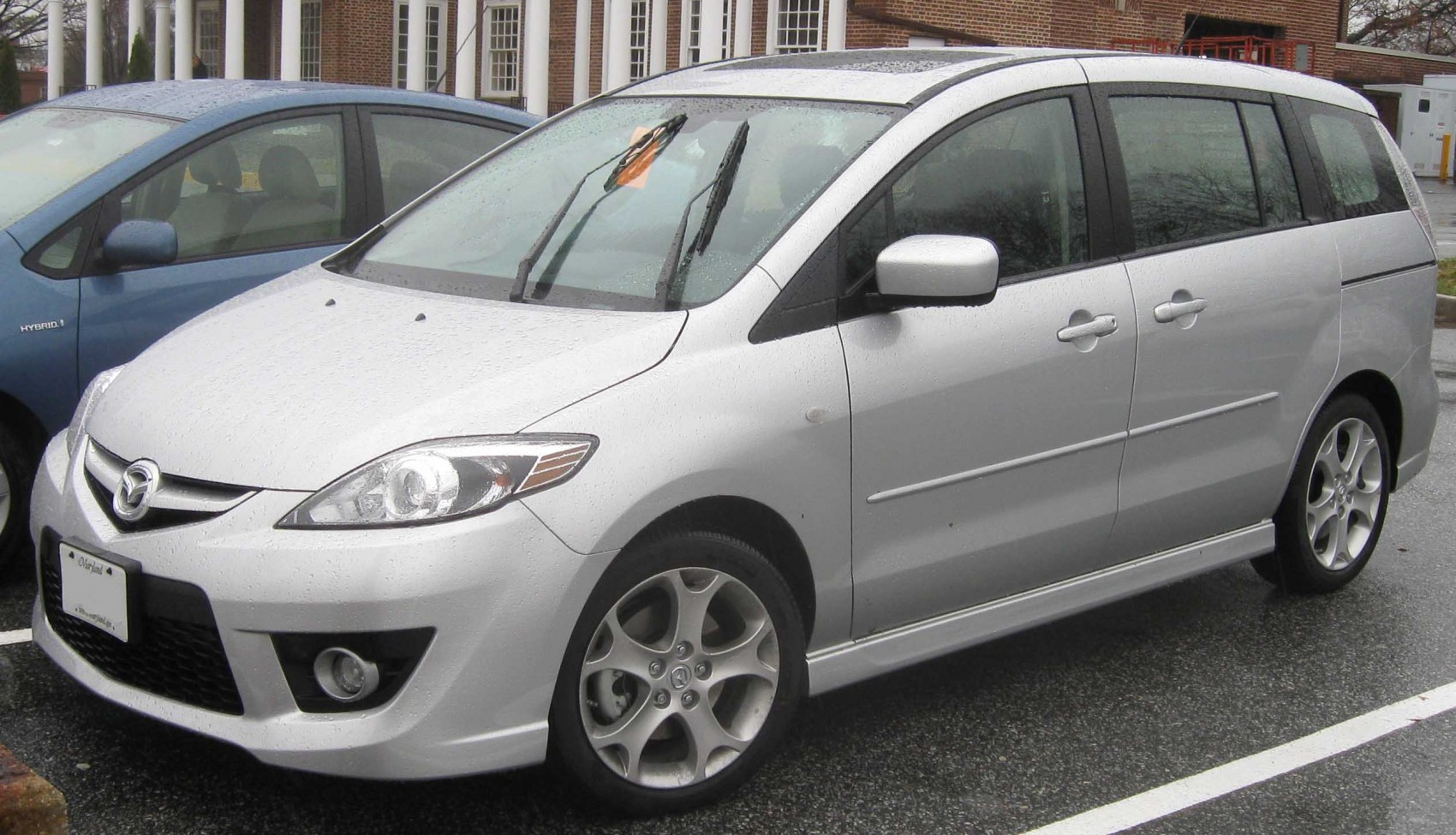 Silver MPV with alloy wheels and fog lights on wet pavement