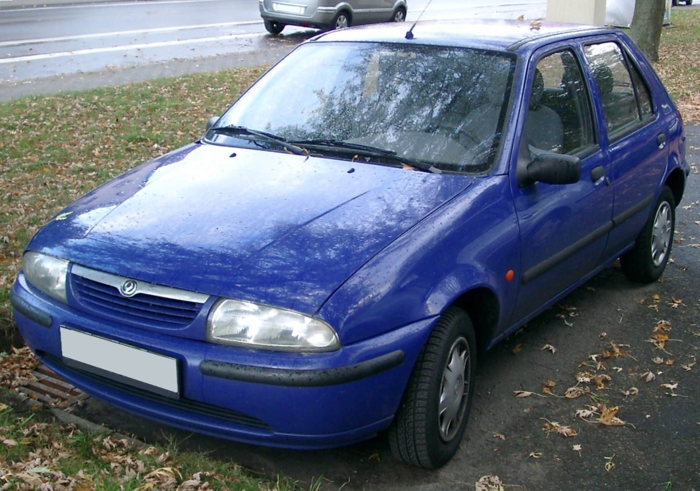 Compact hatchback with rounded headlights and black bumper trim