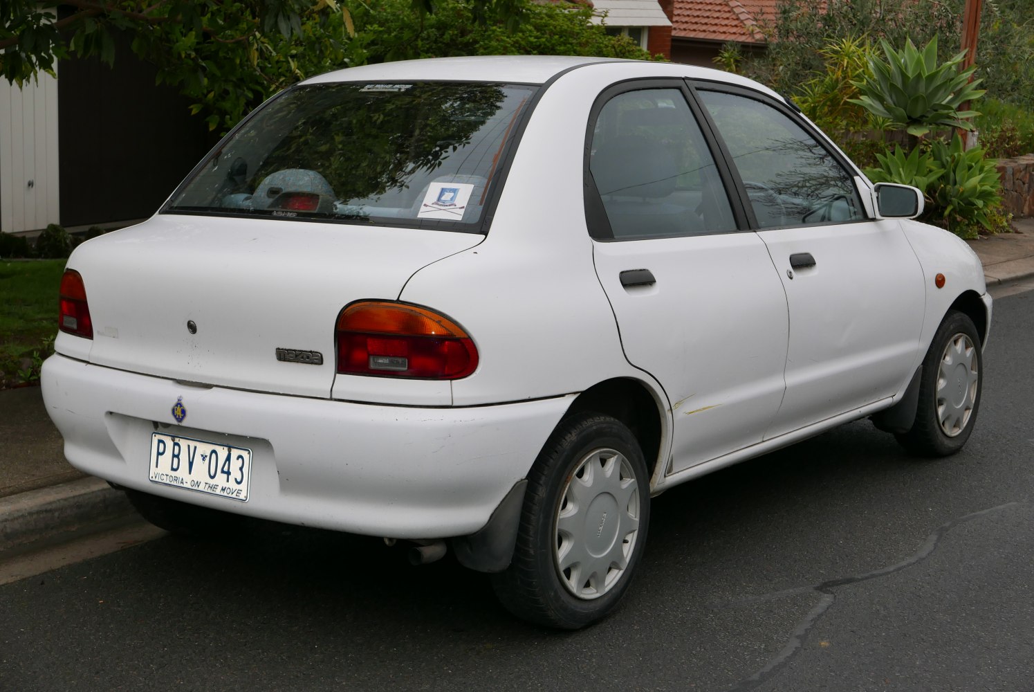 Compact sedan rear with rounded taillights and white exterior.