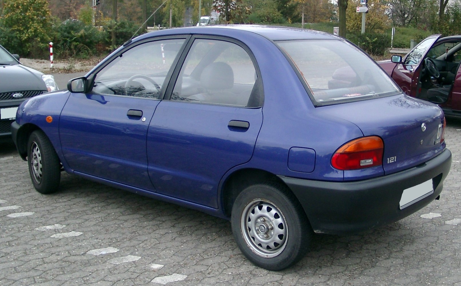 Rear side view of a compact sedan with rounded taillights and four doors
