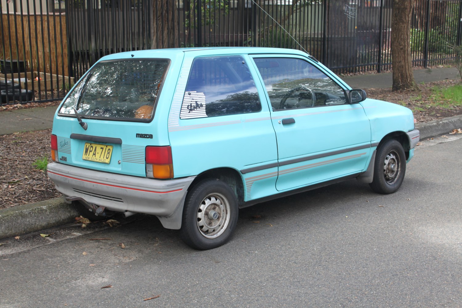 Rear side view of a compact vintage hatchback with distinctive rear window design