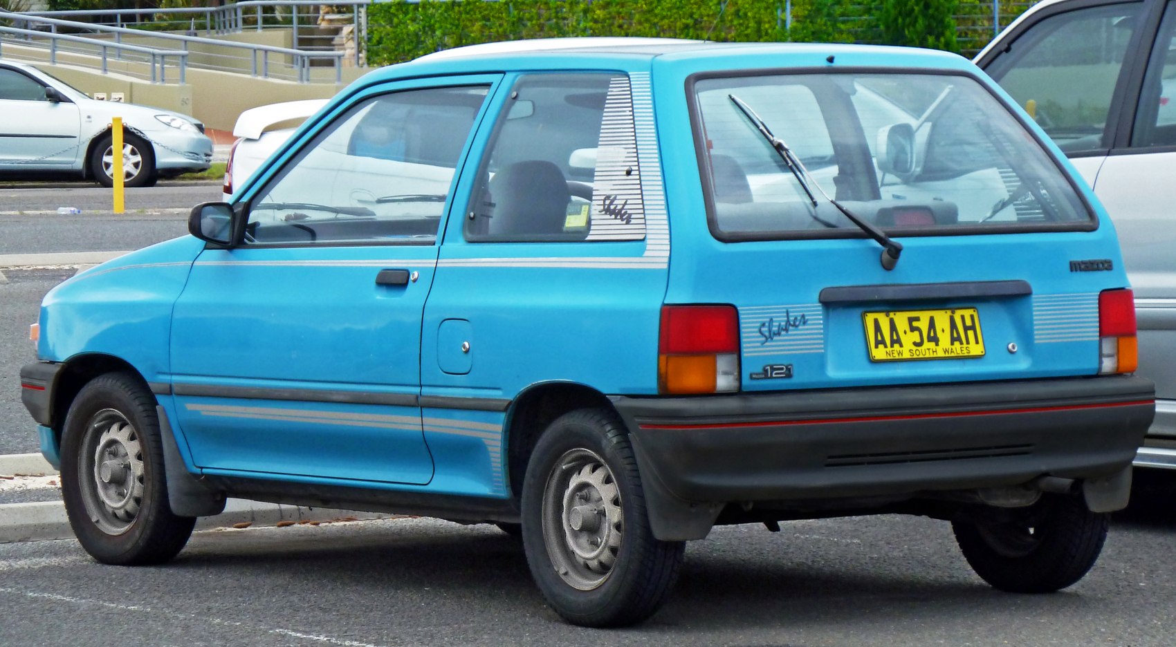 Rear-side view of a blue 1988 hatchback with rear wiper and classic taillights